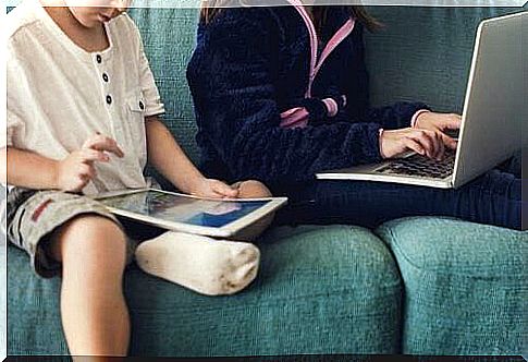 Children sitting on tablet and laptop