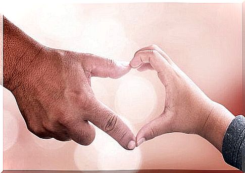 Hand of an elderly man forming a heart with the hand of a child