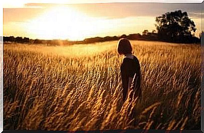 Woman in wheat field thinks about self-image