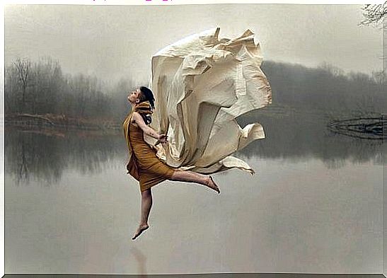 Woman dancing freely on a lake, as an example of how life should be lived according to the slow-movement